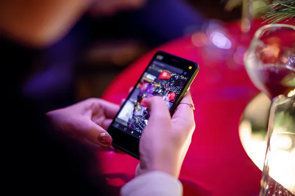 A cheerful woman in traditional clothing using her smartphone during a festive moment, showing how easily the KC666 app fits into everyday life.