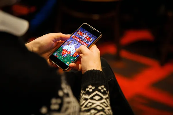 A man focused on his laptop with live stats in the background, highlighting the dedicated sports and gaming features of the KC666 mobile app.